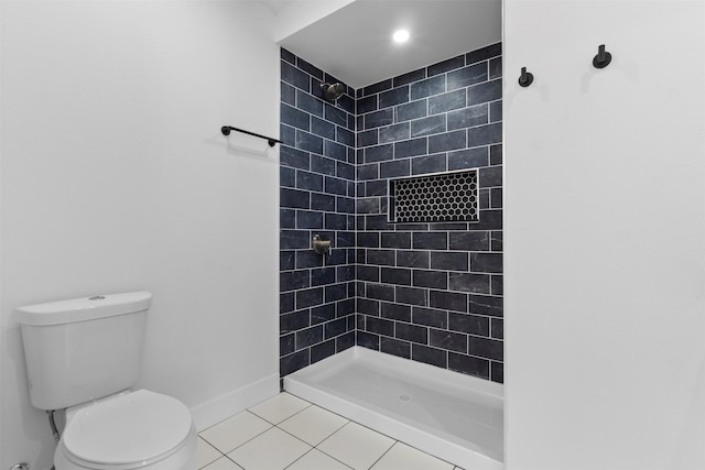 full bathroom with a tile shower, tile patterned floors, baseboards, and toilet