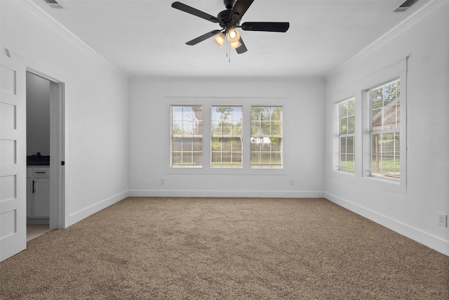 spare room featuring crown molding, visible vents, baseboards, and light carpet