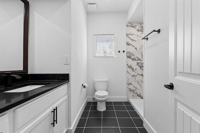 bathroom with a shower stall, vanity, toilet, tile patterned floors, and baseboards
