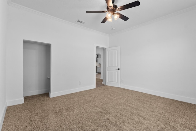 unfurnished bedroom with crown molding, ceiling fan, visible vents, carpet flooring, and baseboards