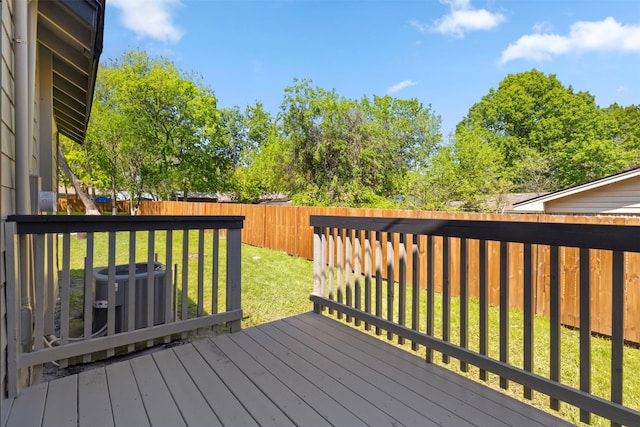 wooden deck with central air condition unit, a yard, and a fenced backyard