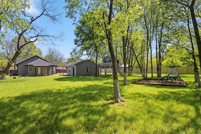 view of yard featuring an outbuilding, fence, and a playground