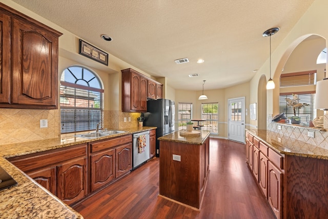 5038 W Fall Dr, Midlothian, TX 76065 - kitchen with dark wood-style flooring, a center island, light stone countertops, appliances with stainless steel finishes, and a sink