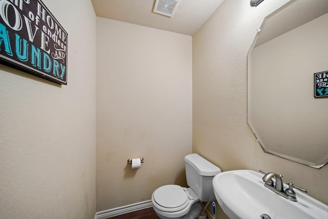 5038 W Fall Dr, Midlothian, TX 76065 - bathroom with visible vents, baseboards, a sink, toilet, and wood finished floors