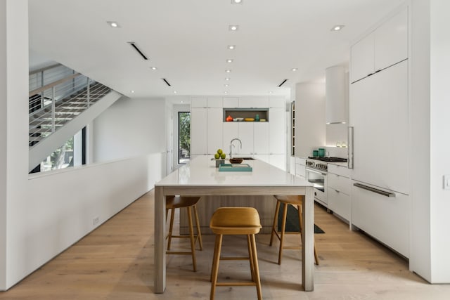 5101 Vickery Blvd, Dallas, TX 75206 - kitchen featuring range with gas cooktop, modern cabinets, white cabinets, a breakfast bar area, and recessed lighting