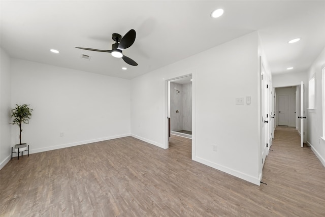 empty room featuring wood finished floors, baseboards, and ceiling fan