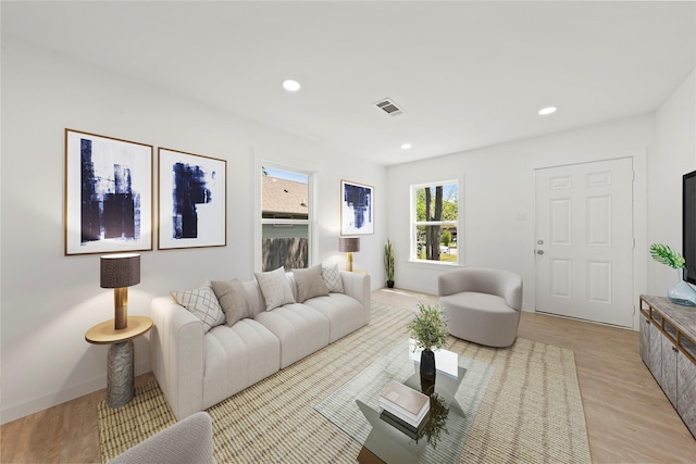 living room with recessed lighting, light wood-type flooring, and visible vents