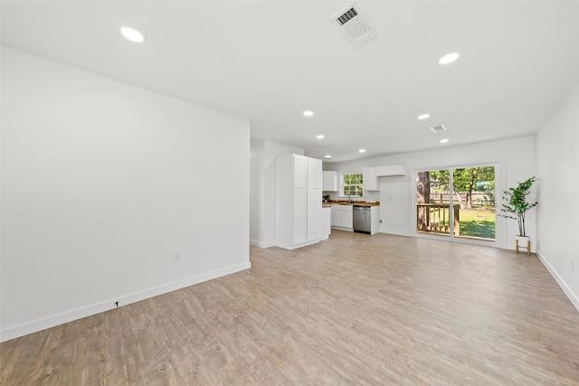 unfurnished living room with light wood finished floors, baseboards, visible vents, and recessed lighting