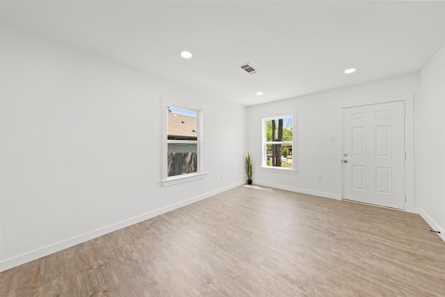 spare room with baseboards, light wood finished floors, visible vents, and recessed lighting