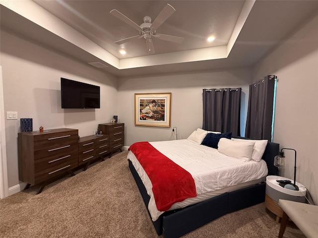 bedroom featuring carpet, ceiling fan, baseboards, and a raised ceiling
