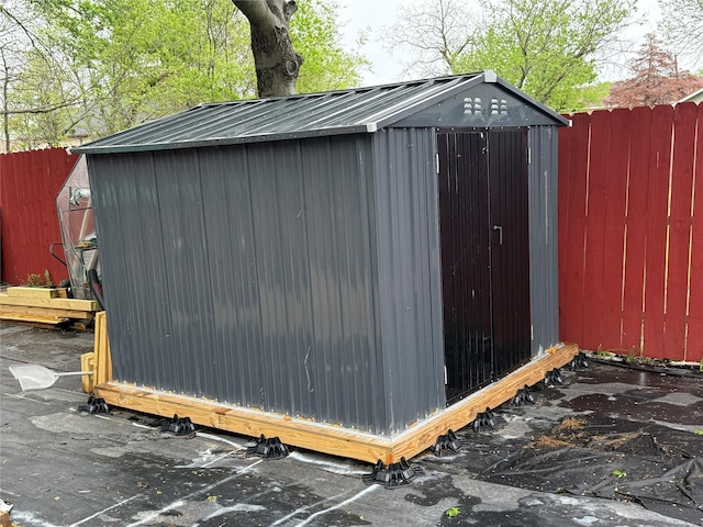 view of shed featuring fence