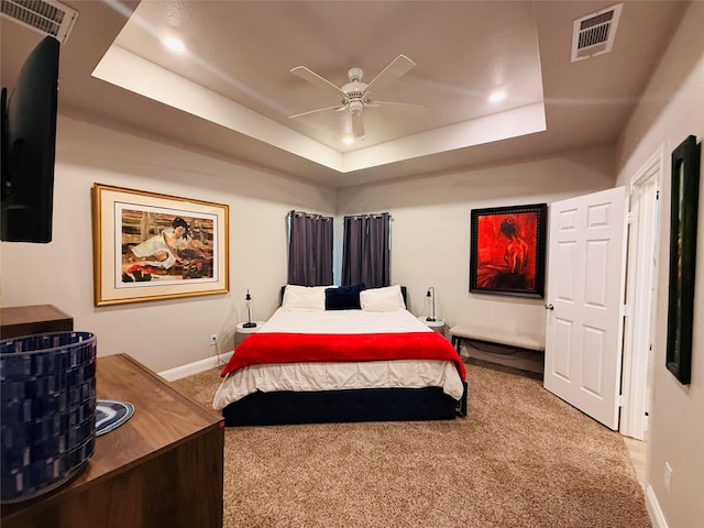bedroom featuring a raised ceiling, carpet flooring, baseboards, and visible vents