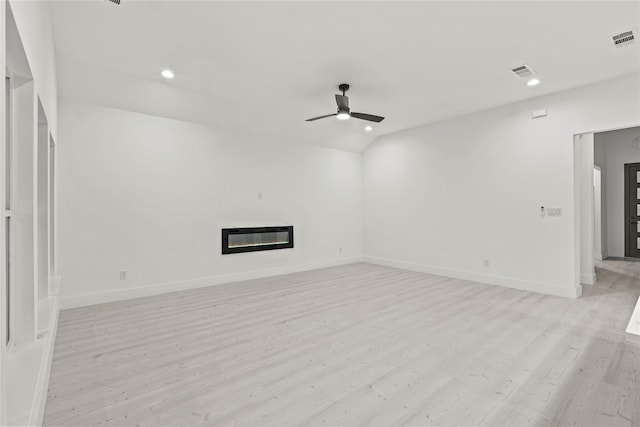 unfurnished living room with visible vents, ceiling fan, light wood-type flooring, heating unit, and a glass covered fireplace