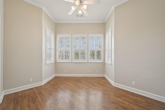 spare room with crown molding, a ceiling fan, visible vents, and plenty of natural light