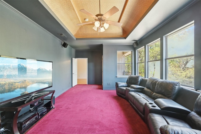 living room with baseboards, a raised ceiling, carpet floors, visible vents, and ceiling fan