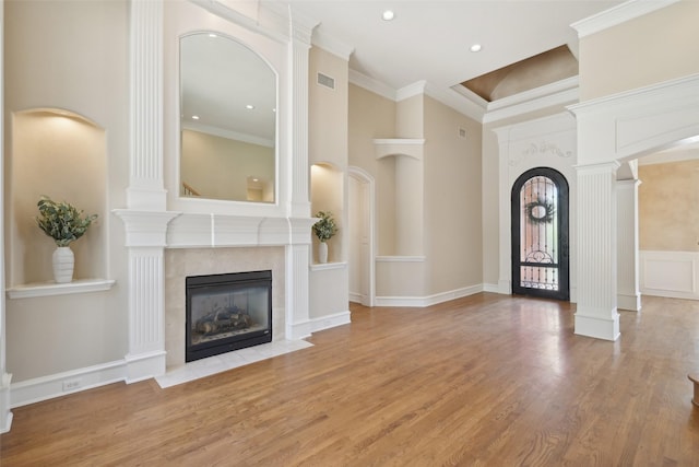 foyer entrance with recessed lighting, a fireplace, crown molding, visible vents, and wood finished floors