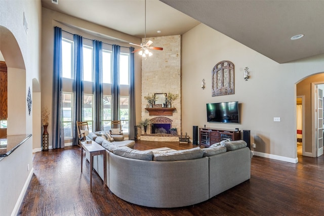 912 Lorene Dr, Wylie, TX 75098 - living room with arched walkways, high vaulted ceiling, dark wood-style floors, a ceiling fan, and a fireplace