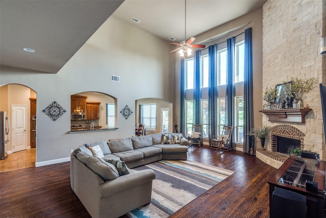 912 Lorene Dr, Wylie, TX 75098 - living area featuring a large fireplace, arched walkways, wood finished floors, and a high ceiling