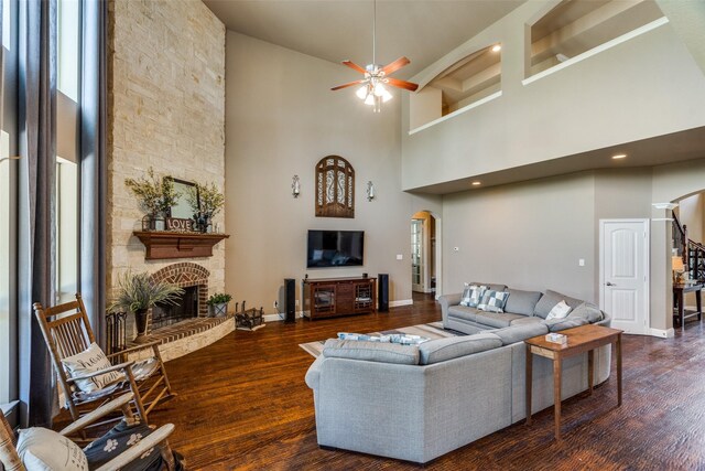 912 Lorene Dr, Wylie, TX 75098 - living area with arched walkways, a towering ceiling, a large fireplace, ceiling fan, and wood finished floors