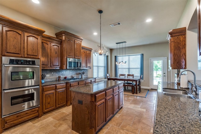 912 Lorene Dr, Wylie, TX 75098 - kitchen featuring appliances with stainless steel finishes, stone tile floors, a sink, a chandelier, and tasteful backsplash