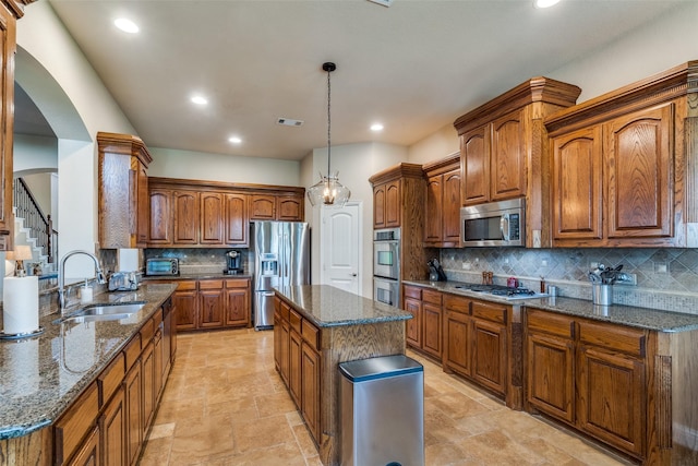 912 Lorene Dr, Wylie, TX 75098 - kitchen with a sink, appliances with stainless steel finishes, decorative backsplash, arched walkways, and dark stone countertops