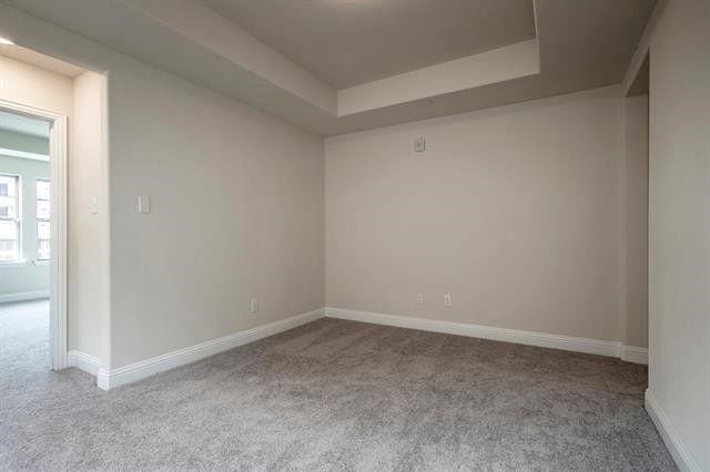 930 Estelle Dr, Euless, TX 76040 - spare room featuring carpet, a tray ceiling, and baseboards