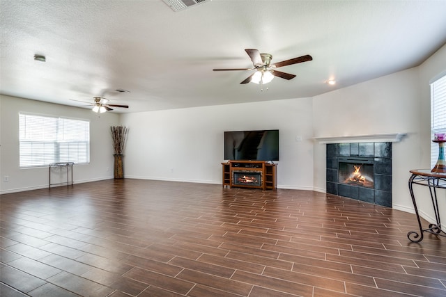 2027 Pine Knot Dr, Heartland, TX 75126 - unfurnished living room with a fireplace, a ceiling fan, dark wood-style flooring, and baseboards