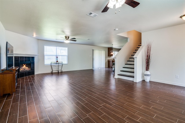 2027 Pine Knot Dr, Heartland, TX 75126 - unfurnished living room featuring ceiling fan, stairway, a fireplace, and dark wood-style floors