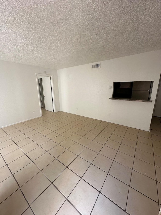 919 S Weatherred Dr Unit 113, Richardson, TX 75080 - empty room featuring a textured ceiling and light tile patterned floors