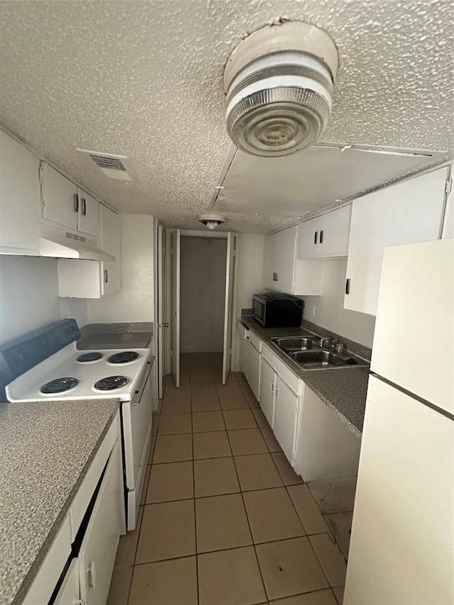 919 S Weatherred Dr Unit 113, Richardson, TX 75080 - kitchen featuring white appliances, white cabinets, tile patterned floors, a sink, and under cabinet range hood