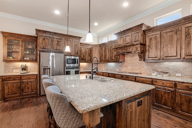 kitchen with a sink, appliances with stainless steel finishes, crown molding, and light stone countertops