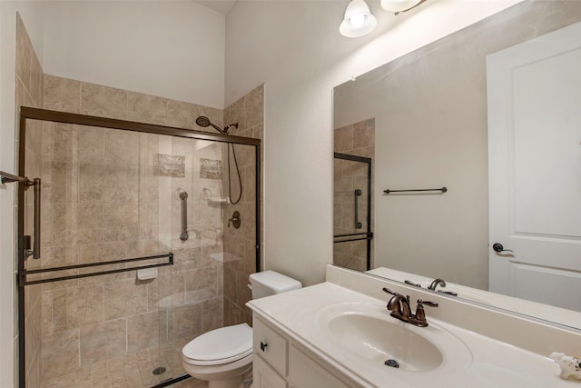 bathroom with toilet, a shower stall, and vanity