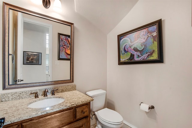 half bathroom featuring toilet, vanity, and lofted ceiling