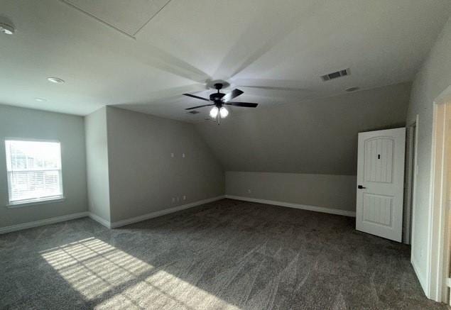 additional living space with visible vents, baseboards, ceiling fan, carpet, and vaulted ceiling