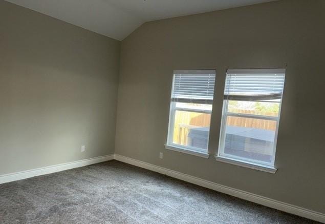 spare room with baseboards, carpet flooring, and vaulted ceiling