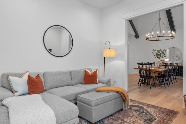 living room with a chandelier, baseboards, and wood finished floors