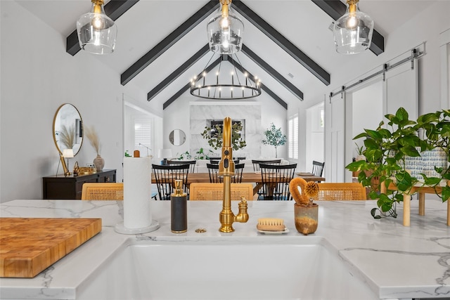 kitchen featuring a barn door, lofted ceiling with beams, plenty of natural light, and a chandelier