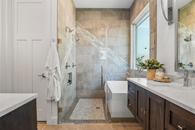 bathroom featuring tile patterned floors, a stall shower, a bathtub, and vanity