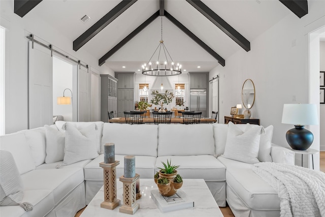 living room featuring beam ceiling, a barn door, a chandelier, and high vaulted ceiling