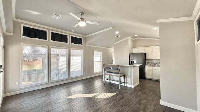 161 Pillsbury Cir, Quitman, TX 75783 - kitchen with a breakfast bar, a center island, black fridge with ice dispenser, visible vents, and ceiling fan