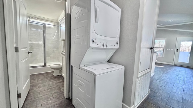 161 Pillsbury Cir, Quitman, TX 75783 - laundry area featuring baseboards, ornamental molding, visible vents, stacked washer / drying machine, and laundry area