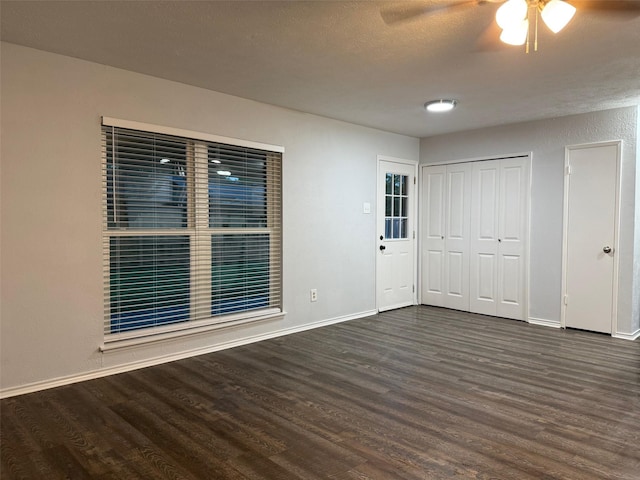 empty room featuring baseboards, a ceiling fan, and wood finished floors