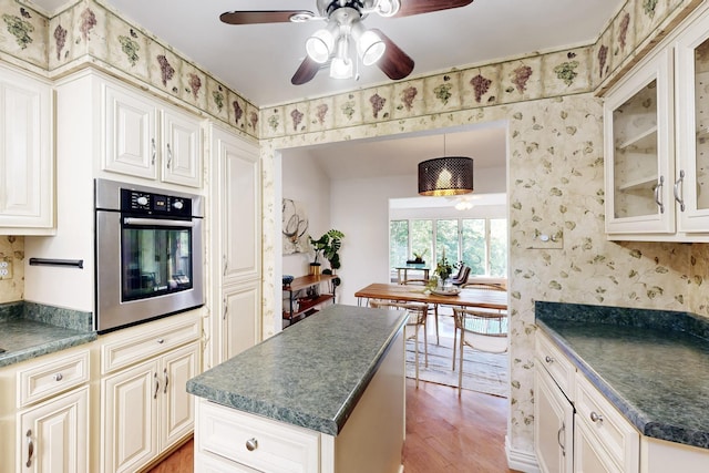 office space featuring ceiling fan, a textured ceiling, baseboard heating, light wood finished floors, and baseboards