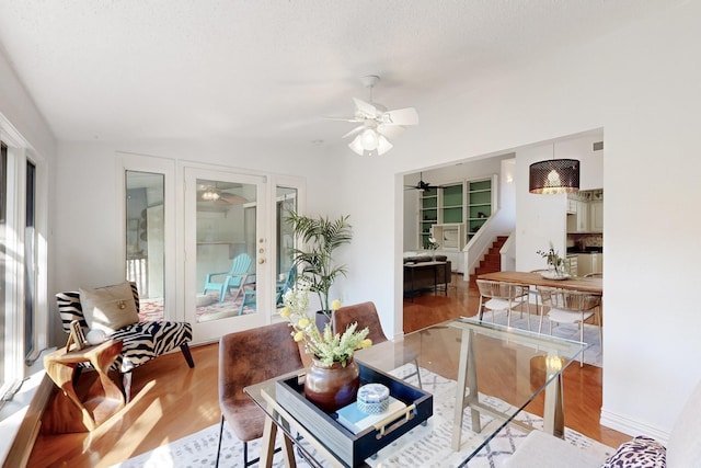 living area featuring visible vents, stairway, wood finished floors, and a ceiling fan