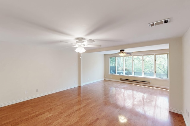 spare room featuring visible vents, ceiling fan, a baseboard radiator, and wood finished floors