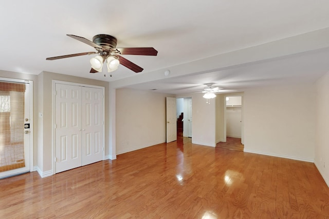 unfurnished room with light wood-style flooring, ceiling fan, and baseboards