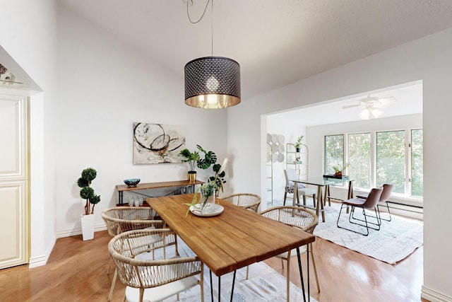 dining area with light wood finished floors, baseboards, and a ceiling fan