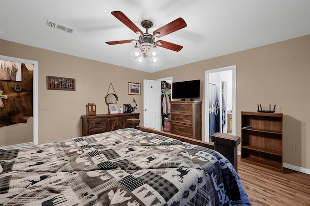 bedroom featuring a closet, baseboards, visible vents, ceiling fan, and wood finished floors