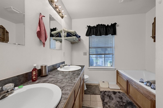 full bath featuring tile patterned flooring, a garden tub, visible vents, and a sink