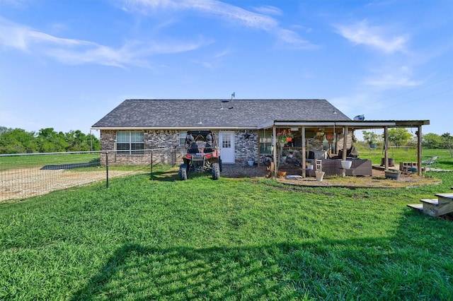 back of property featuring a yard, fence, and a shingled roof